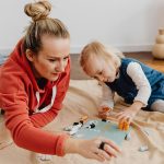 A mother and child enjoying quality time playing a board game at home.