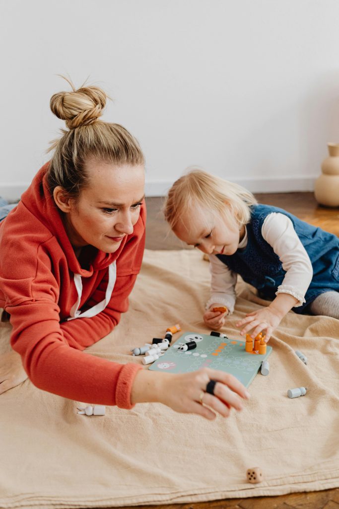 A mother and child enjoying quality time playing a board game at home.